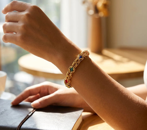 Bracelet byzantin large doré porté au poignet avec une tenue élégante.