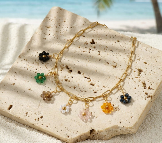 Collier pastoral fleurs et quartz présenté dans une ambiance lumineuse et naturelle.