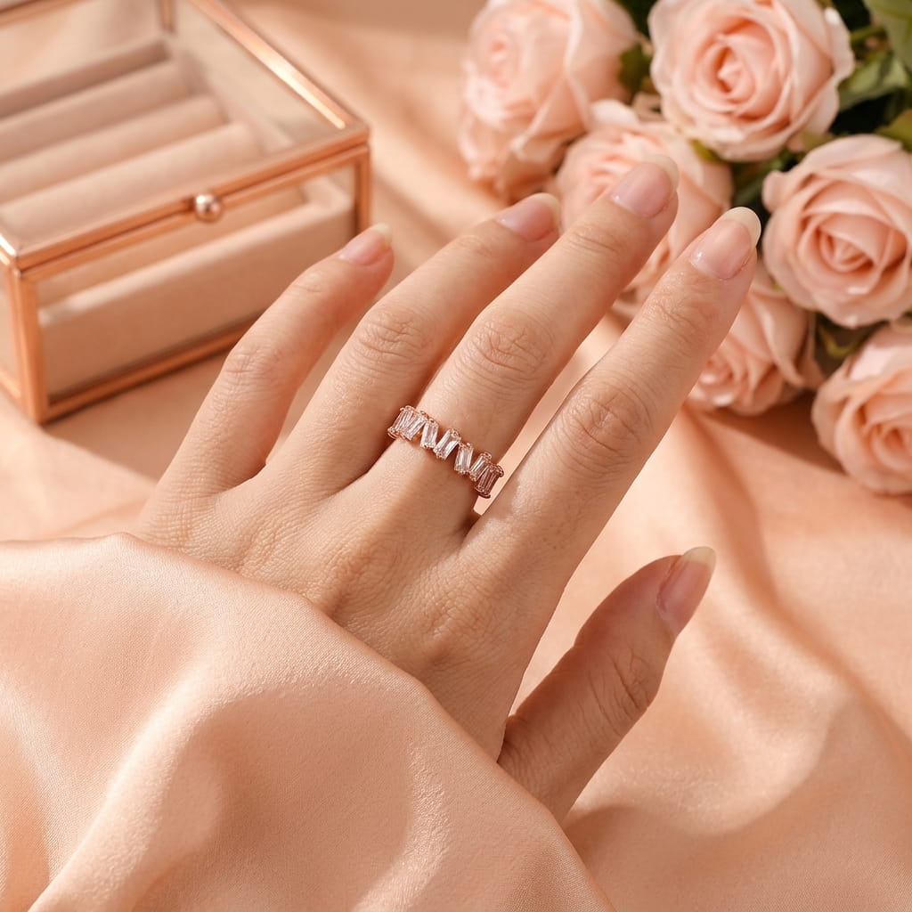 Bague or rose scintillante portée à l'annulaire dans une ambiance douce avec des roses.