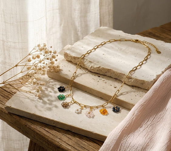 Collier maille trombone doré avec sept petites fleurs en cristal de quartz multicolores.
